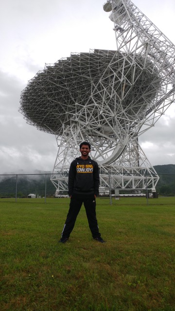 Aman in front of a giant dish.