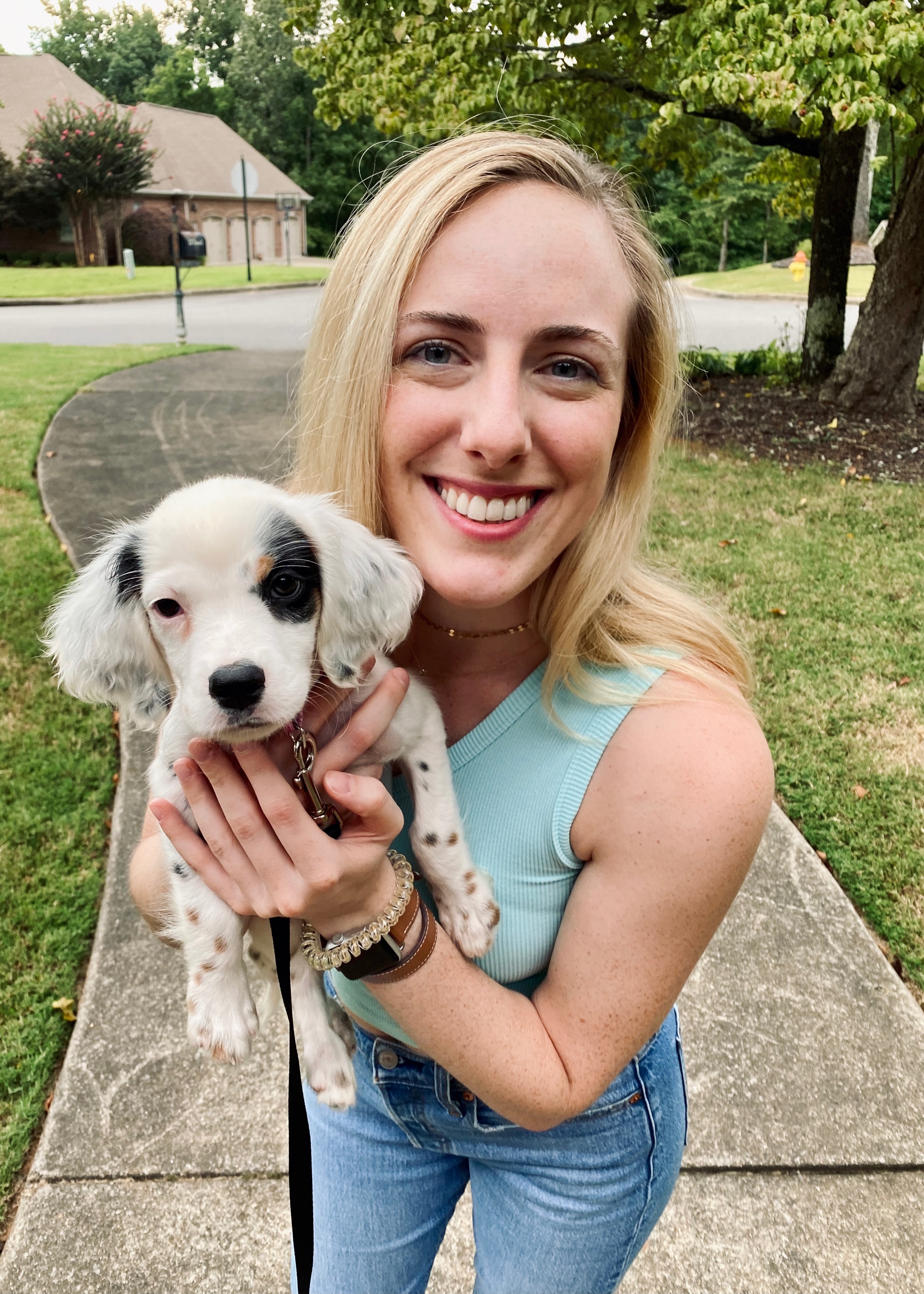 Mary Geer standing outside with an adorable puppy