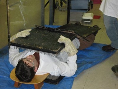 A man in a white lab coat laying on a bed of nails.